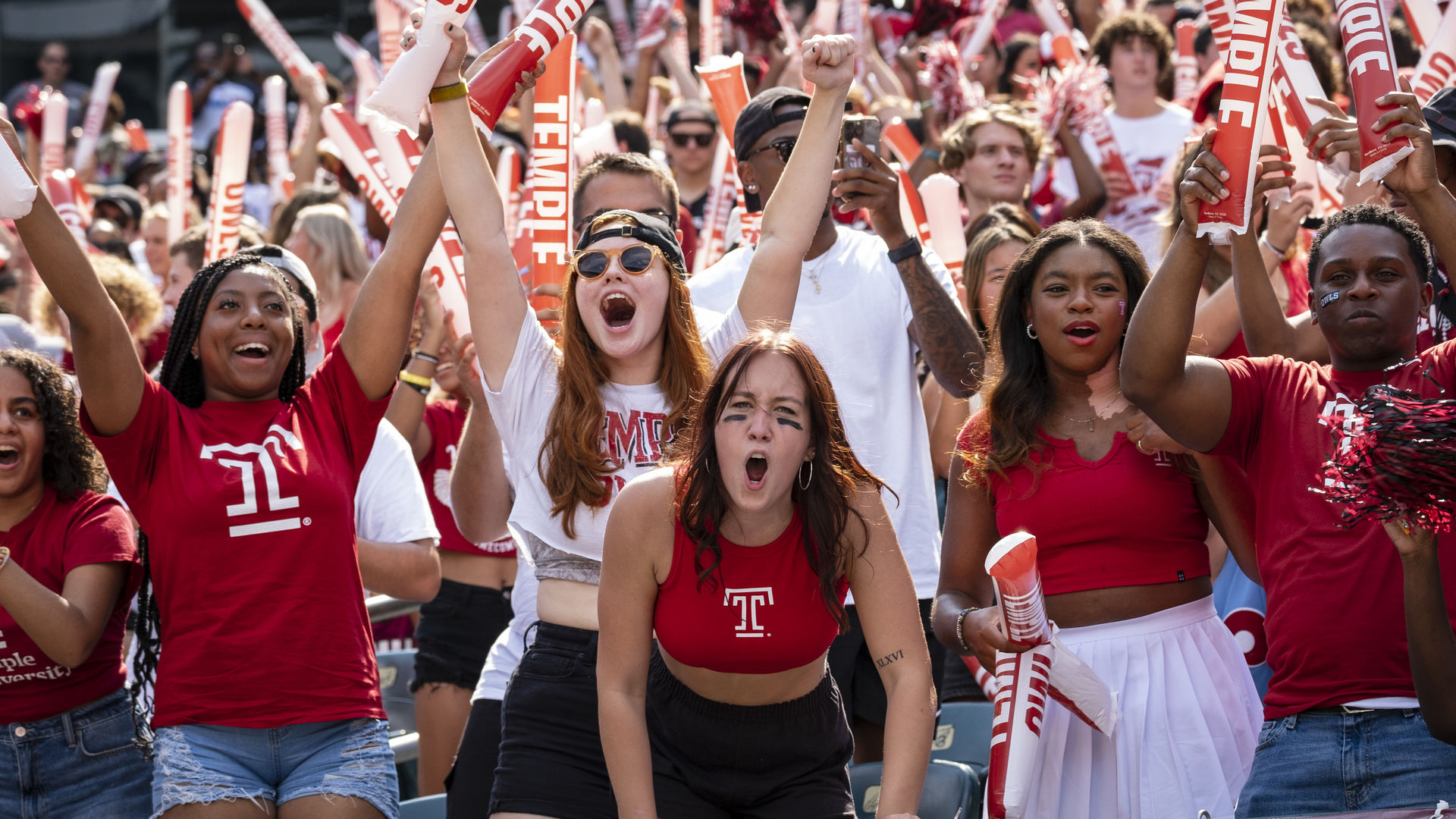 students cheering at a Temple football game.