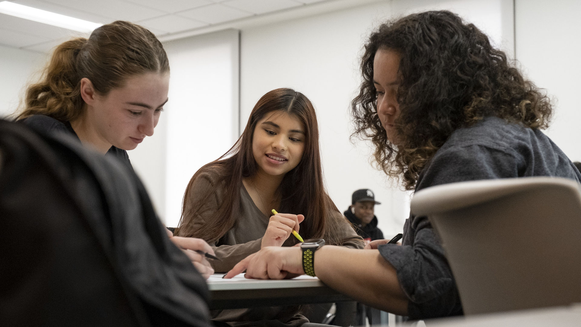 three students work together in class.