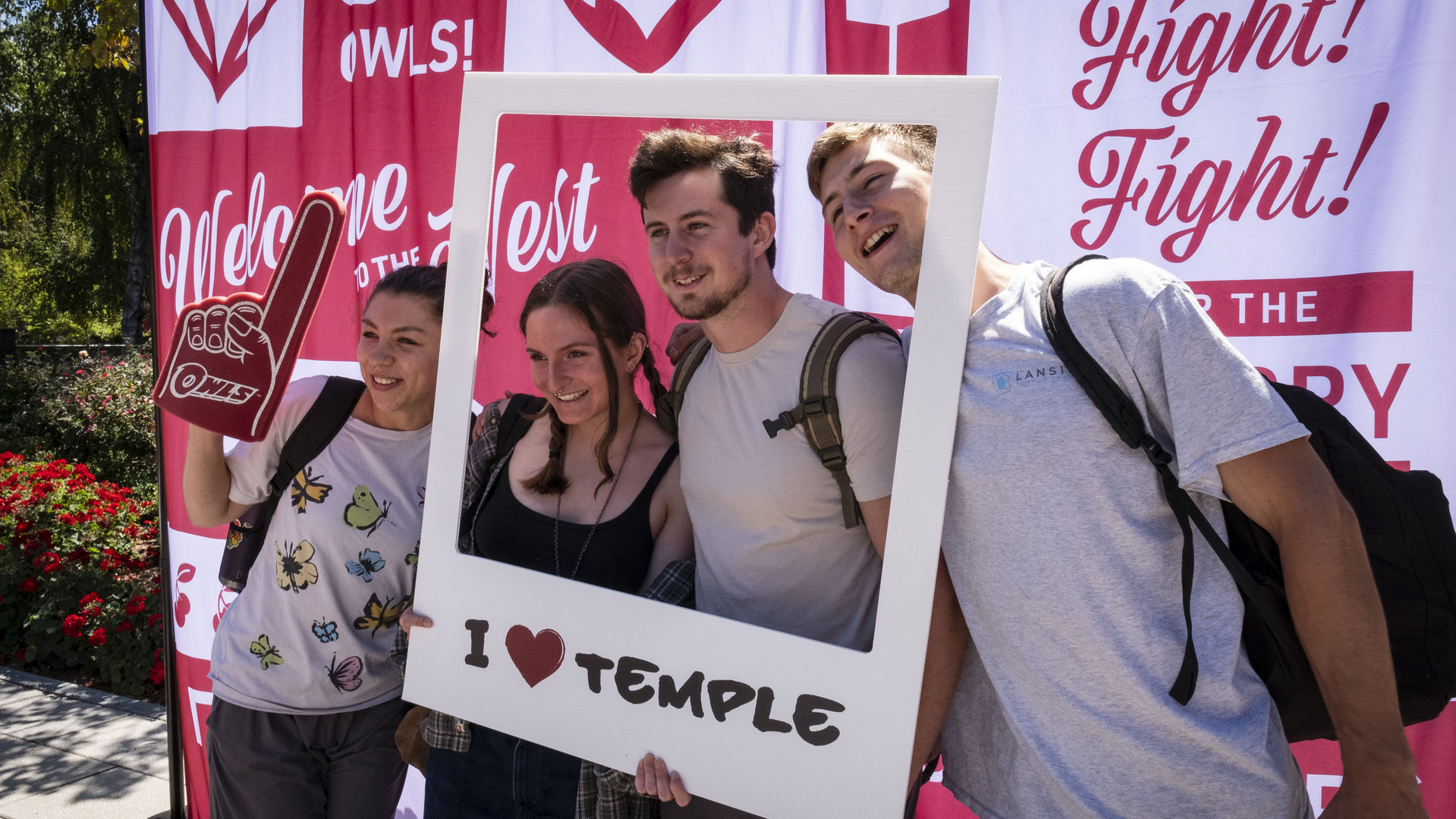 four students pose for a picture with props during a Pep Rally. 