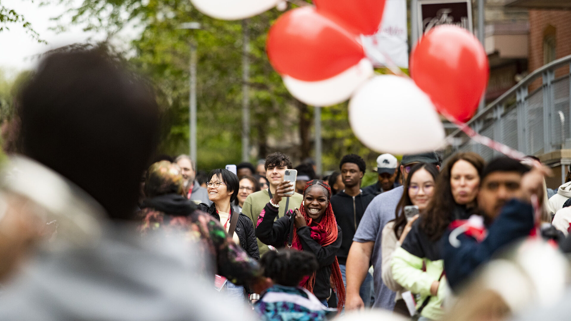 Students walking on campus with balloons.