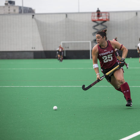 Temple field hockey player moving the ball up the field. 