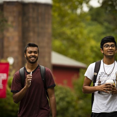 Two smiling students walk outside on Temple's Ambler Campus