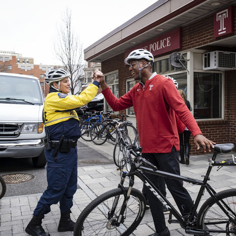 President Wingard high-fiving a member of Temple's Campus Safety team.