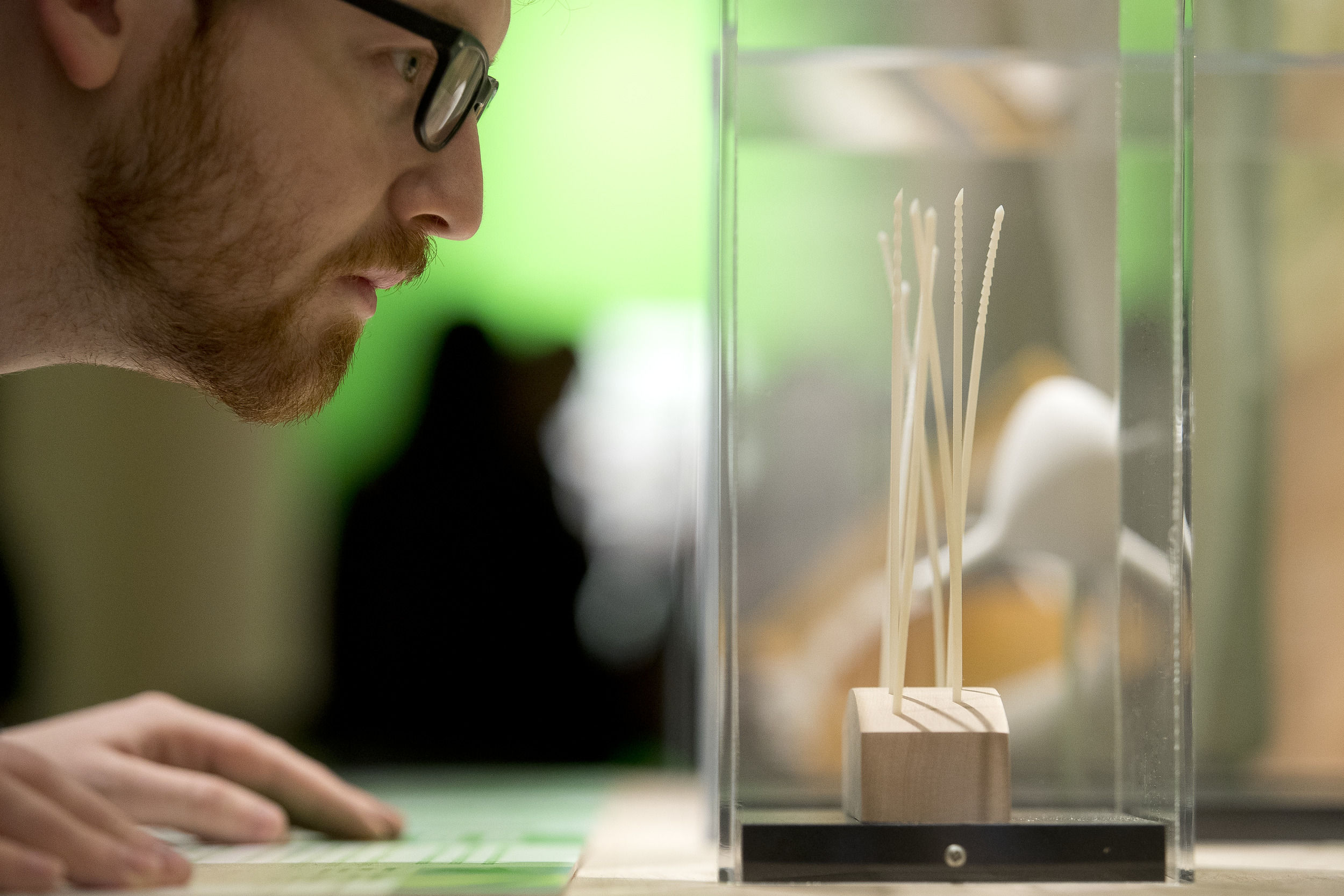 A student examines the 3D needles exhibit at the Charles Library.