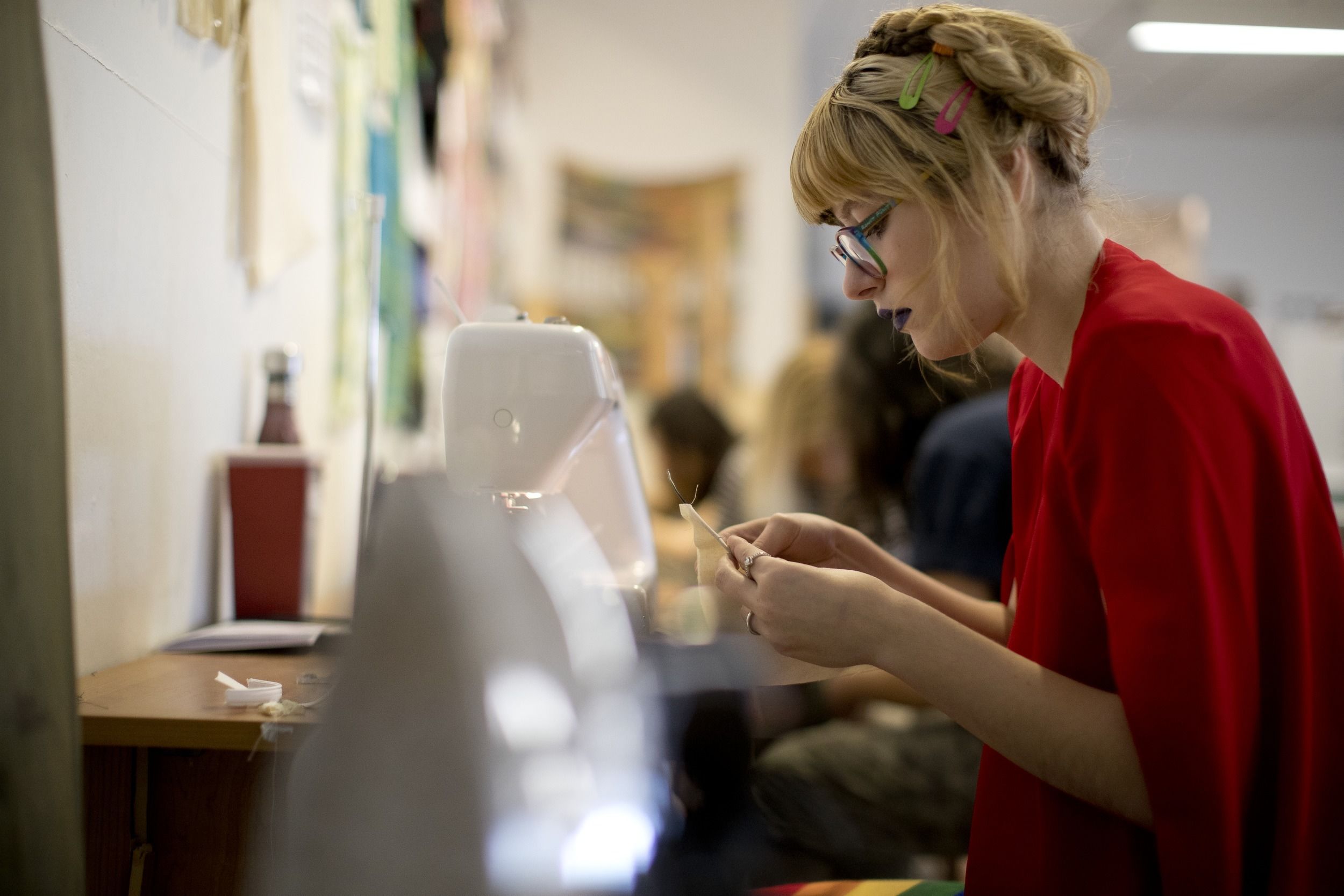 A student works at a sewing machine during class.