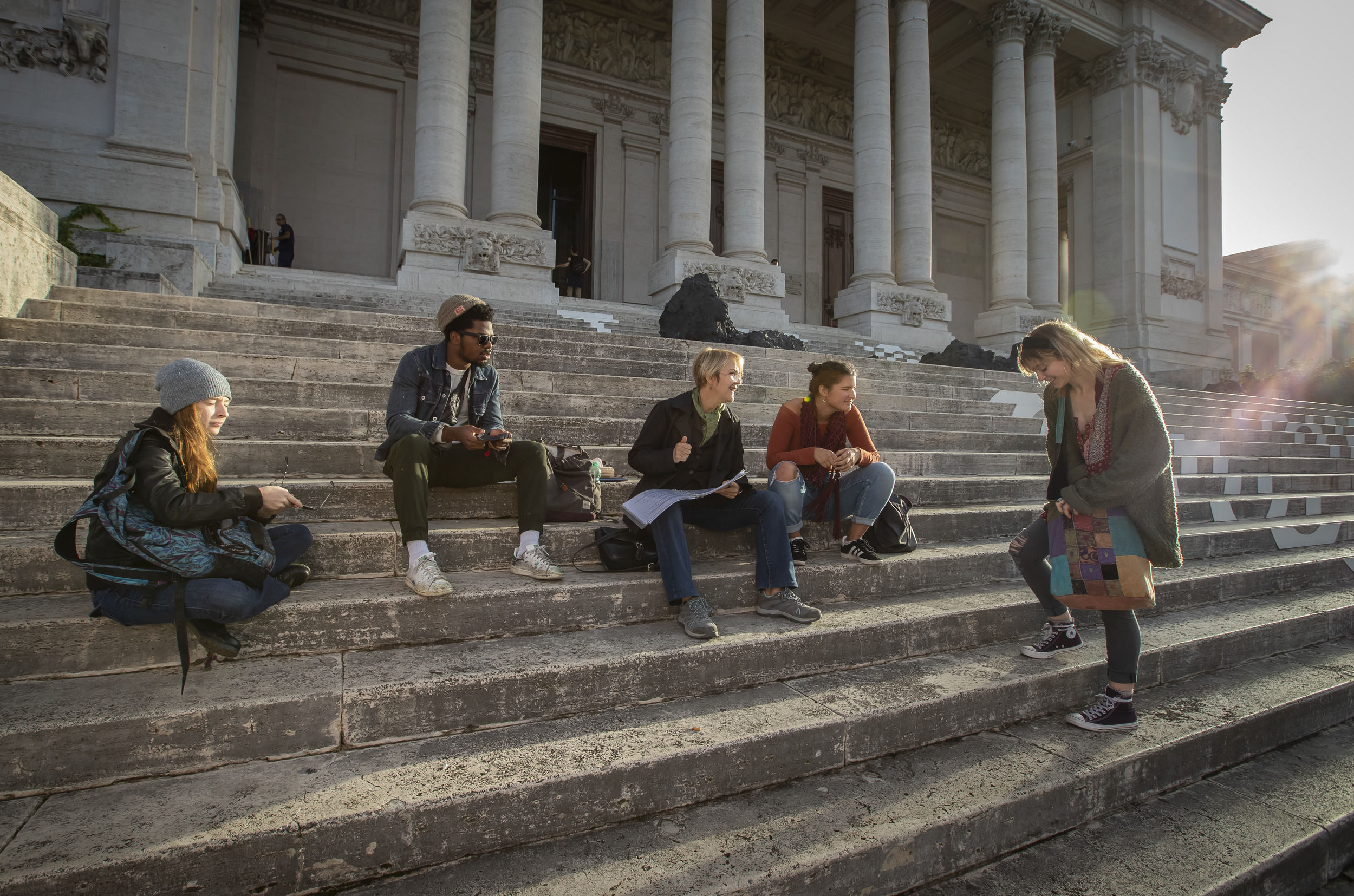 Art students creating sketches on museum steps.