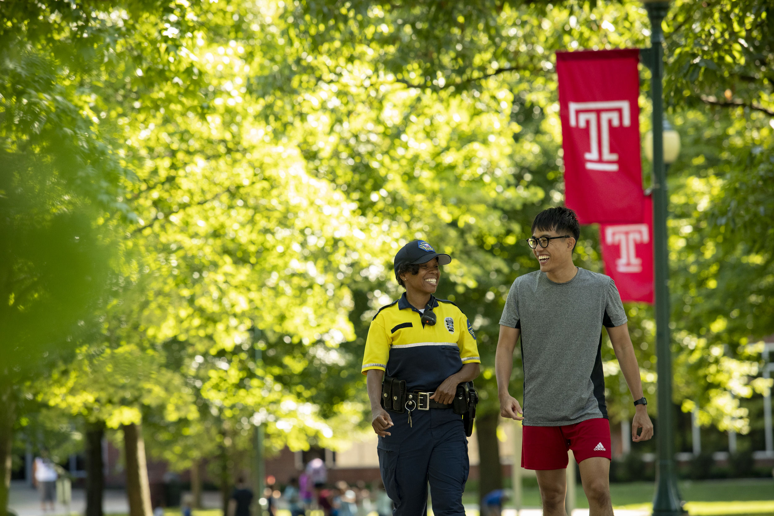 A student walking with Ambler Campus security.