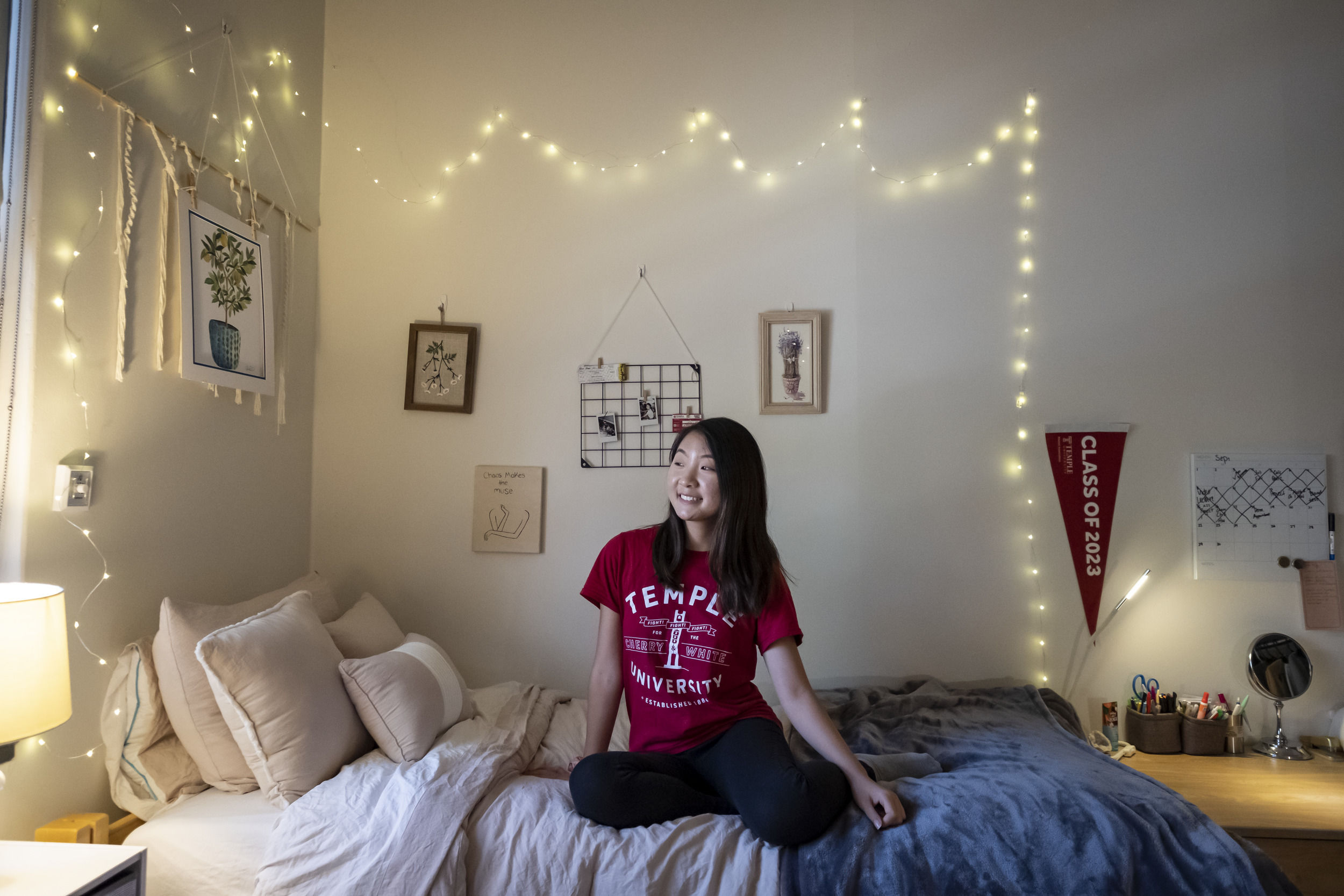 A student sits in their newly decorated room at Temple University.