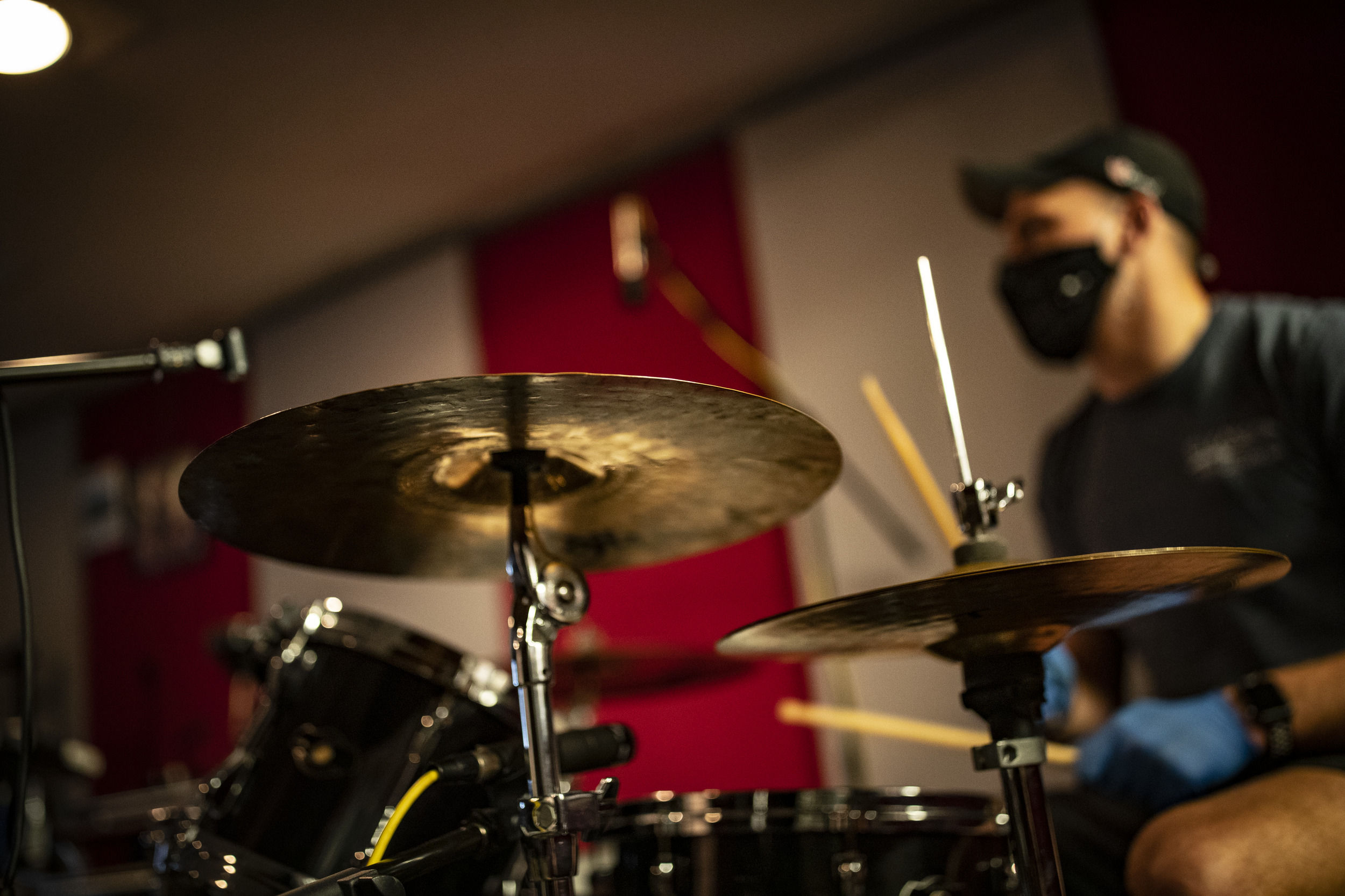 A Klein College of Media and Communications student plays drums during studio music class.