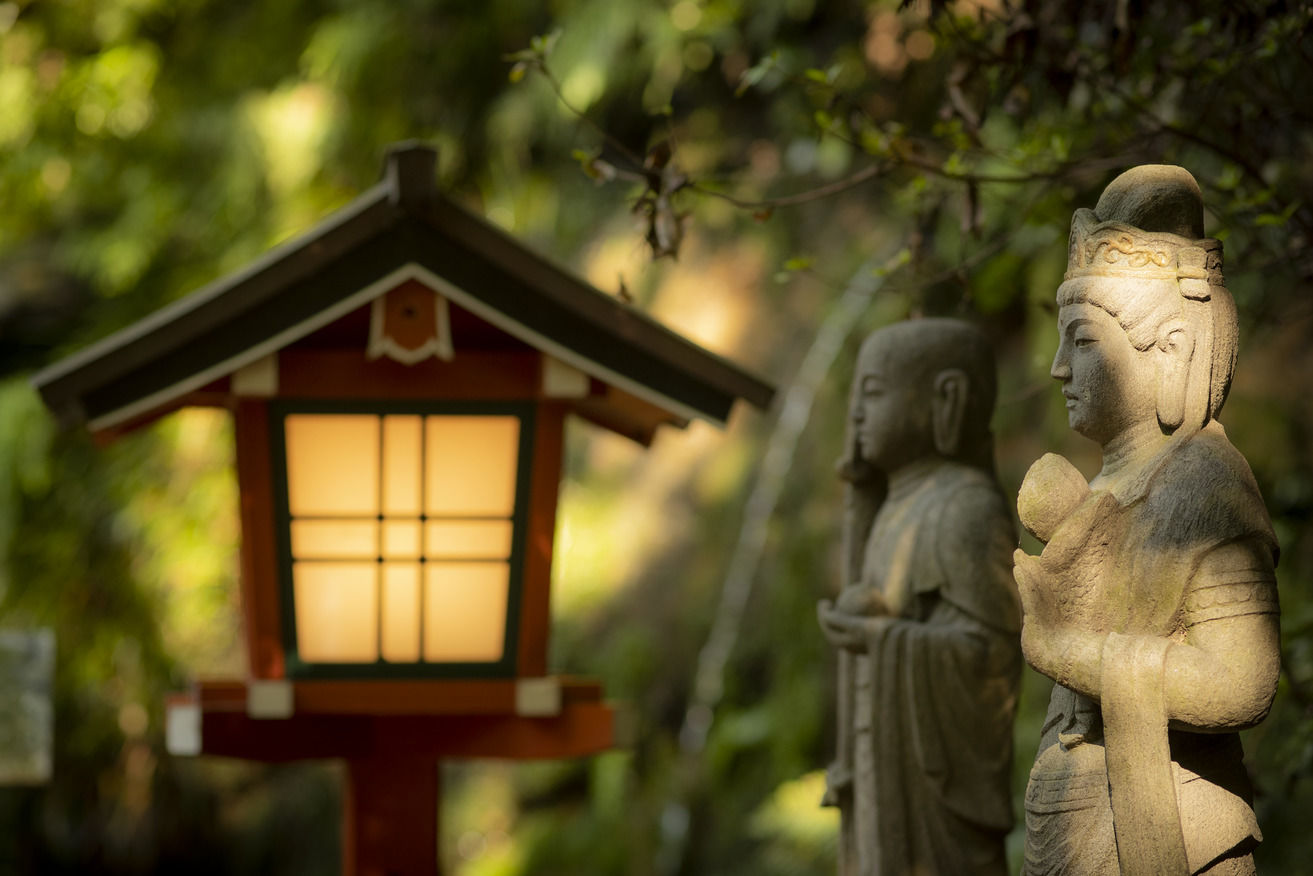 A traditional Japanese lantern and sculptures in a park. 