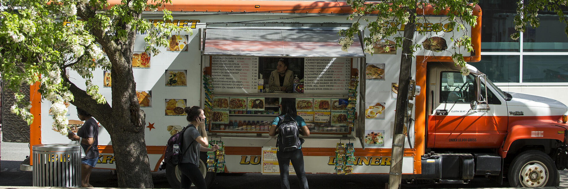 Student waling past food truck on campus.