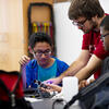 A Temple College of Science and Technology student works with two local Philadelphia high school students