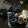 An overhead shot of a Temple student reading notes and working on their laptop.