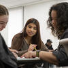 three students work together in class.