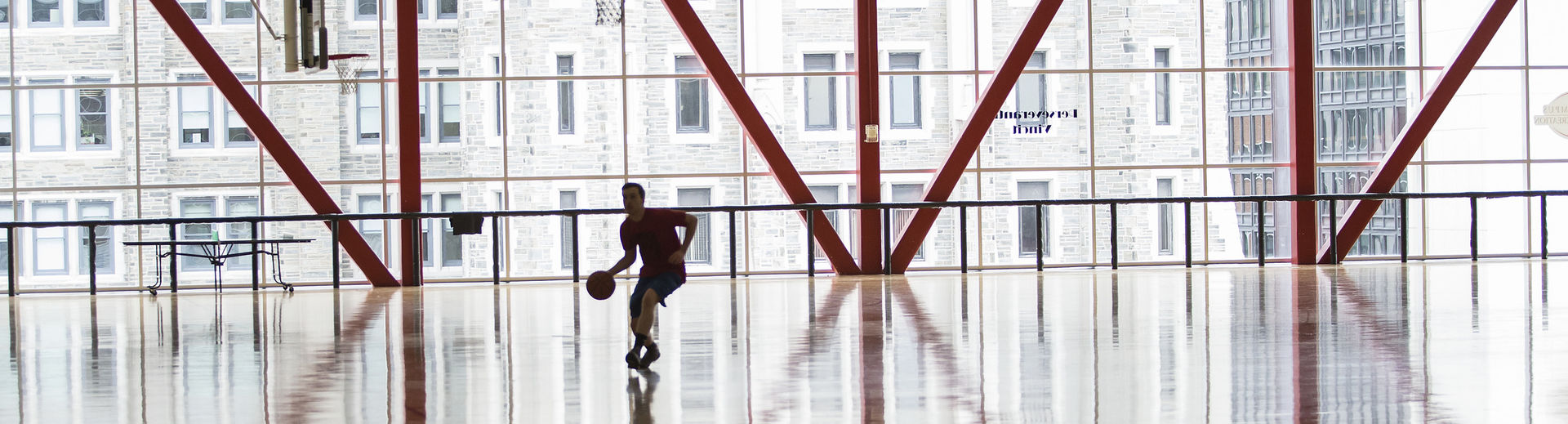 a student practicing basketball alone in the Pearson & McGonigle courts.