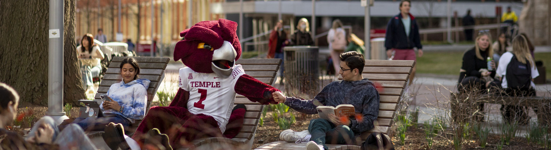 Hooter chatting with student on a bench. 